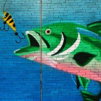Fish about to eat a hook wall art on bricks